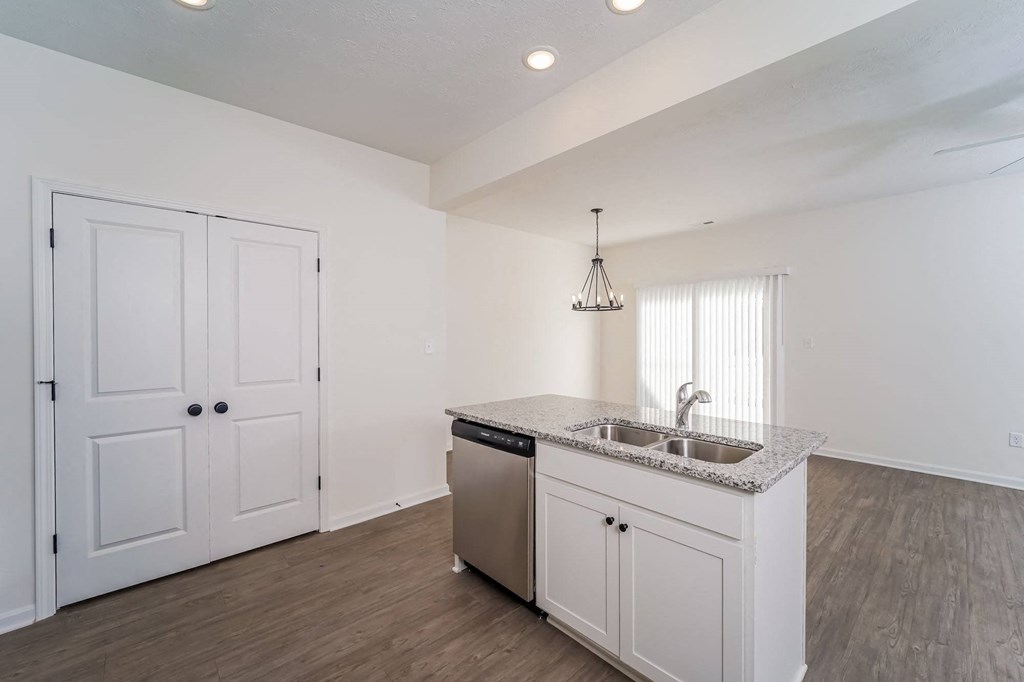 an empty kitchen with a sink and a door to a closet