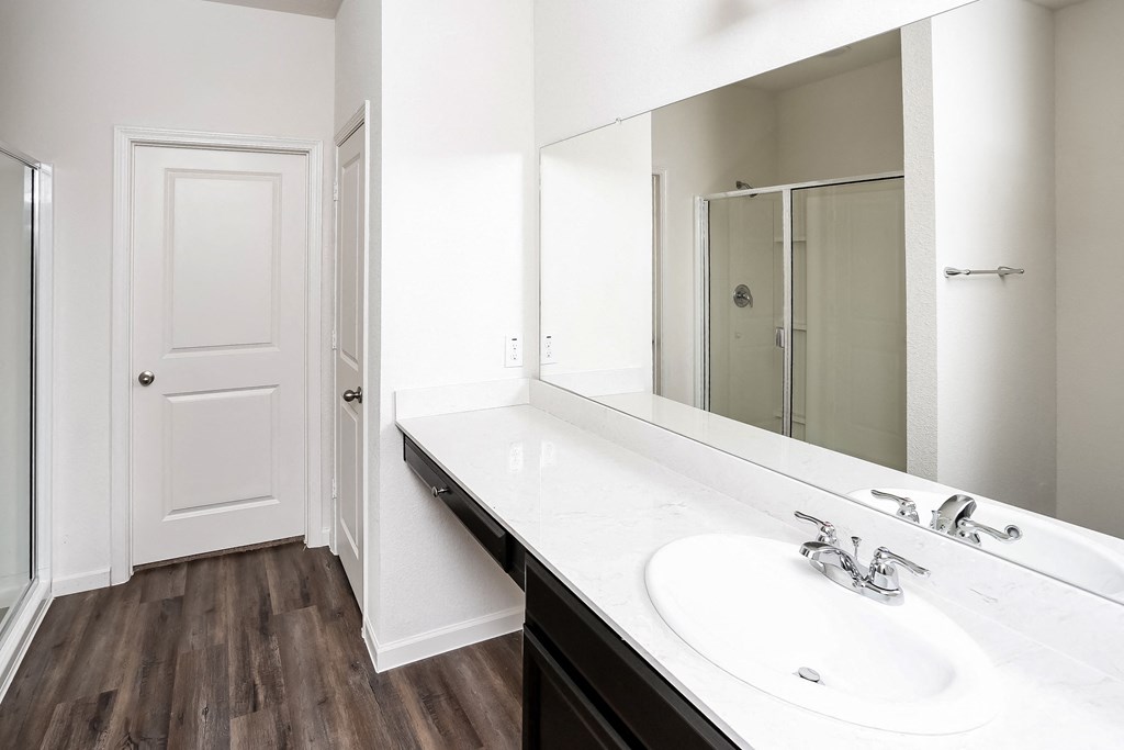 an empty bathroom with a large mirror and a sink