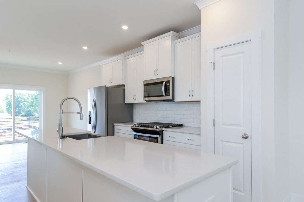 Pet Friendly Townhomes in Lower South End NC - Loso Walk - Modern Kitchen with a Kitchen Island, Stainless Steel Appliances, and White Cabinetry