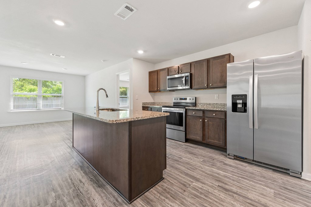 a kitchen with stainless steel appliances and a marble counter top