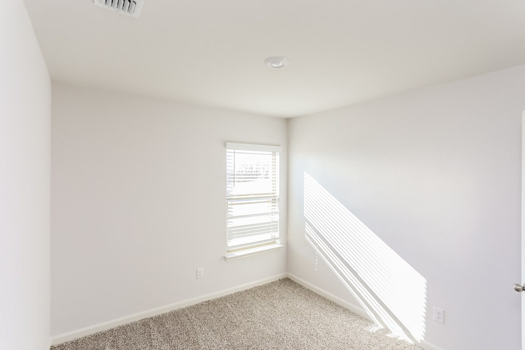 an empty room with white walls and a window