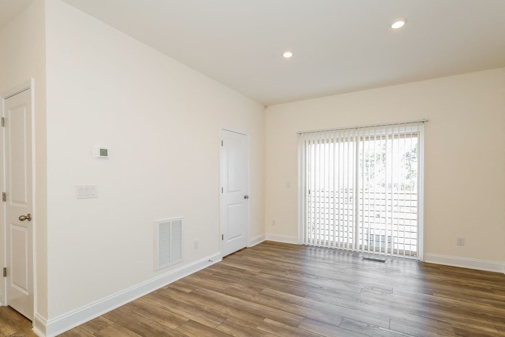 a bedroom with hardwood floors and white walls