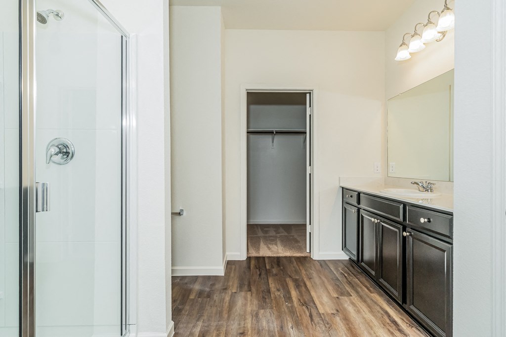 a bathroom with a glass shower and a sink and a mirror