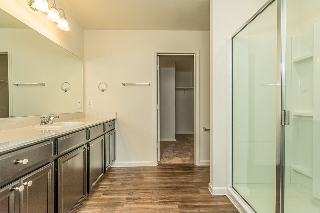 an empty bathroom with a glass shower and sink