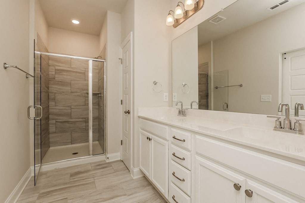 a large white bathroom with a shower and a sink