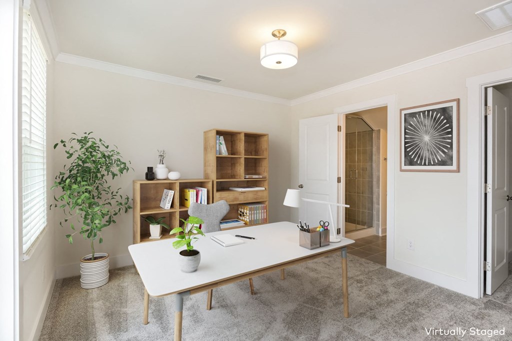 a home office with a large potted plant on the side of the desk