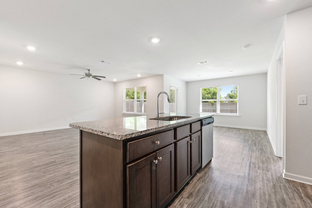 an empty kitchen with a sink and a counter top