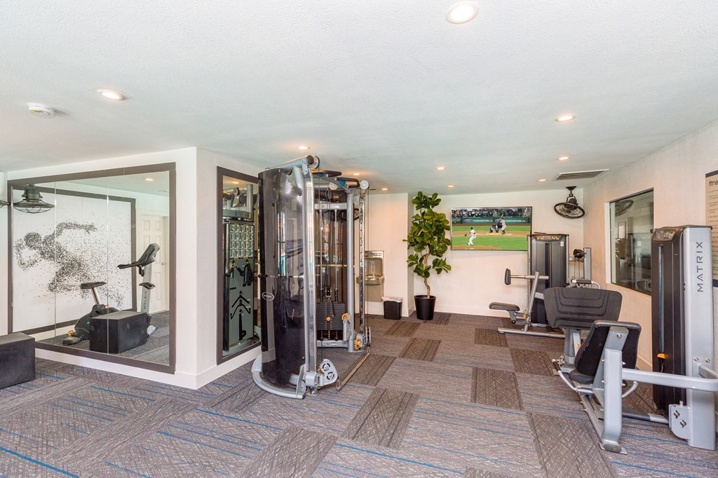 Two-BR Apartments In Moreno Valley, CA - Sorelle Apartments - Fitness Center Equipped With Cardio And Strength Training Machines, Ceiling Fan, TV, Full-Body Mirror, And Water Fountain.