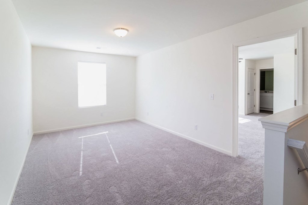 an empty living room with white walls and a window