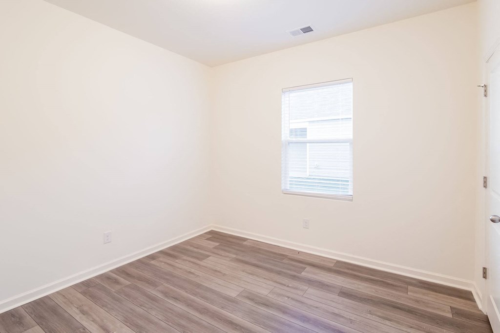 a room with a window and wooden floors