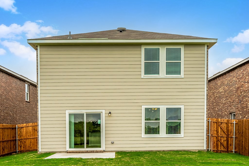 a house with tan siding and a wooden fence