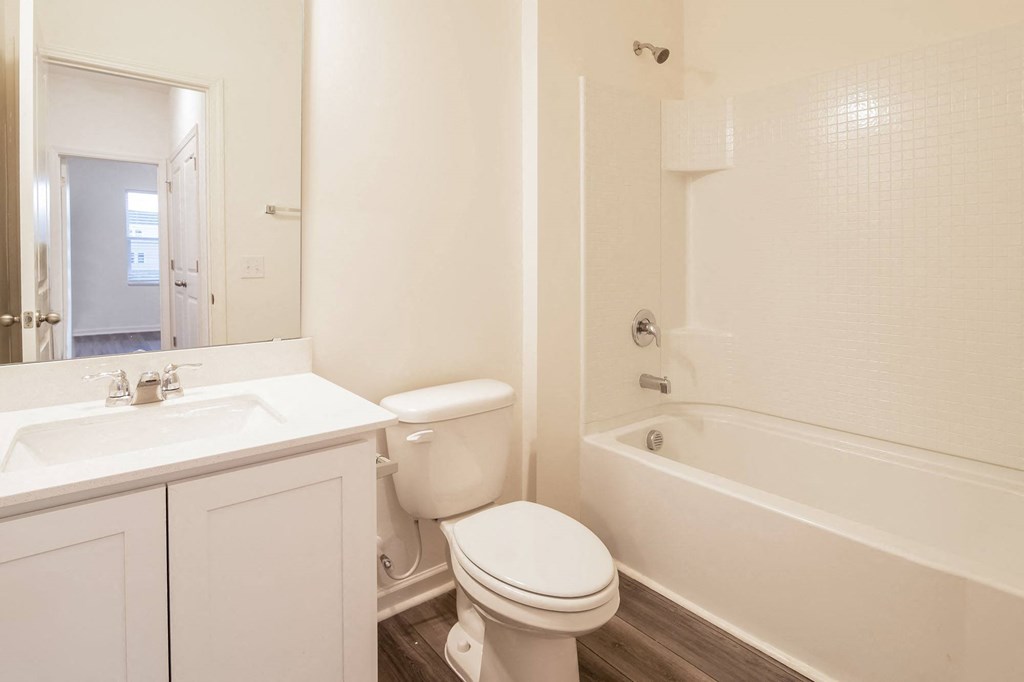a bathroom with a toilet and a tub and a sink