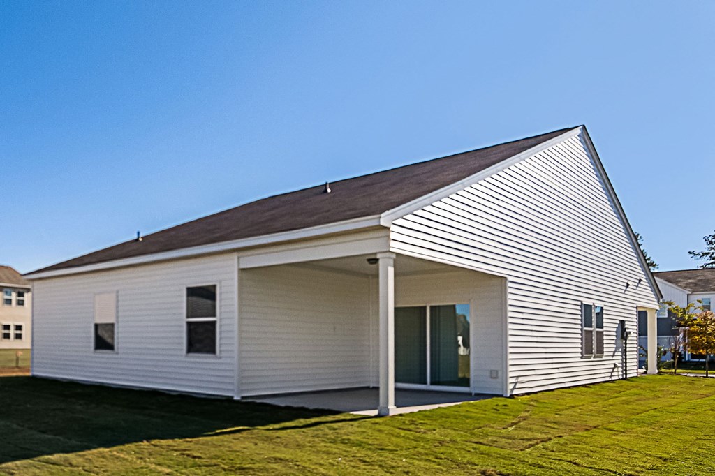 a small white church building with a grass field and a blue sky