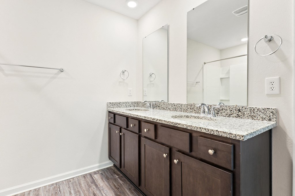 a bathroom with a large mirror and a granite counter top
