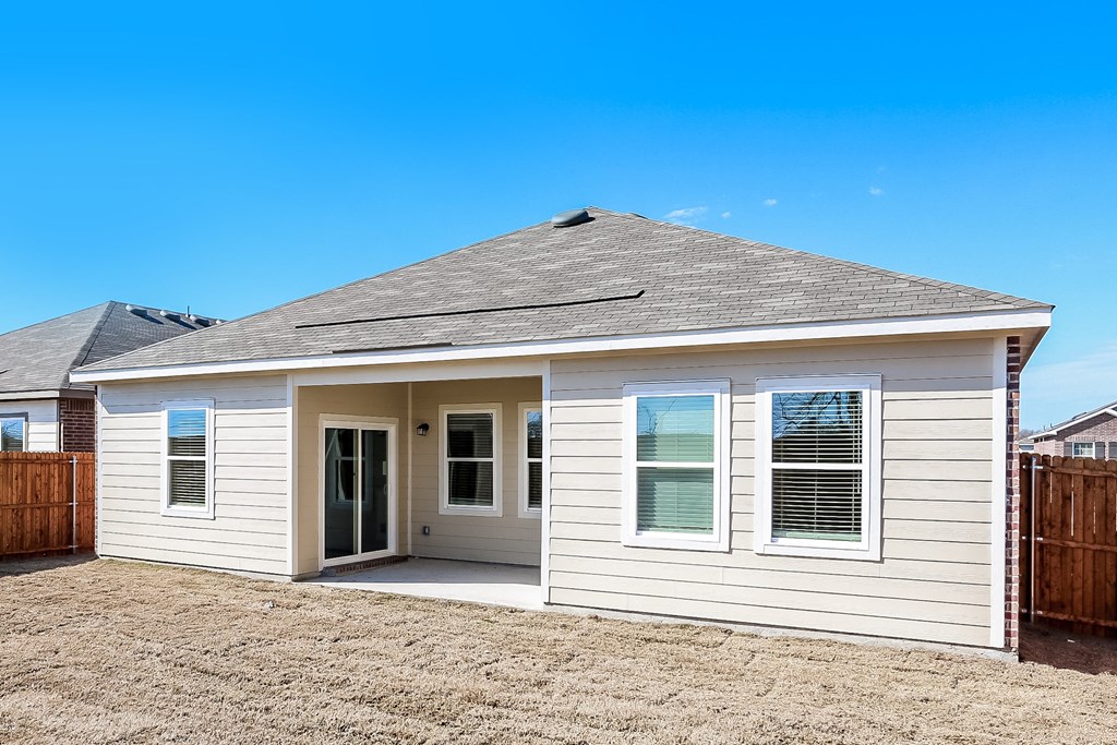 the front of a white house with a yard and a door
