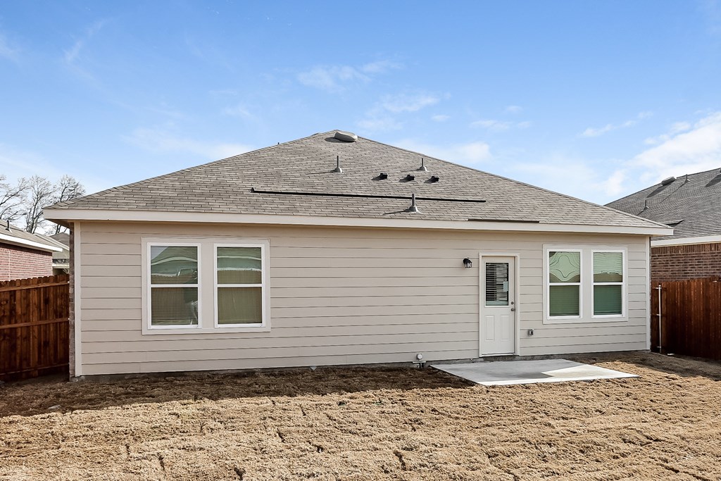 the front of a house with a gravel driveway and a roof