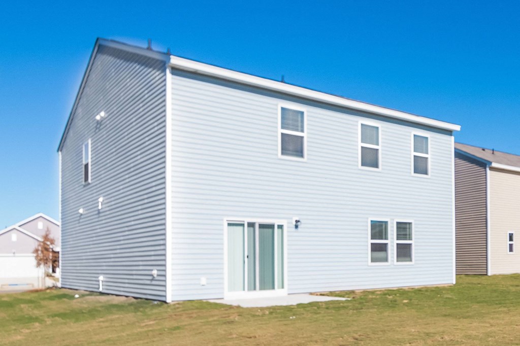 a white house with blue siding and a green door