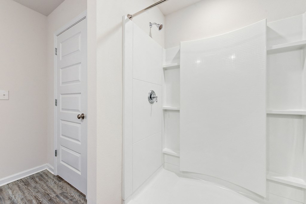 a walk in closet with a white door and a large white closet with white doors