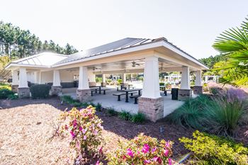 a covered patio with tables and benches in a pavilion