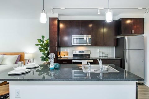 A modern kitchen with dark brown cabinets and a white island.