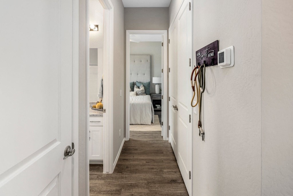 A hallway with a white door and a brown floor.