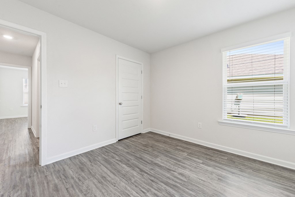 the living room of an apartment with a door and a window