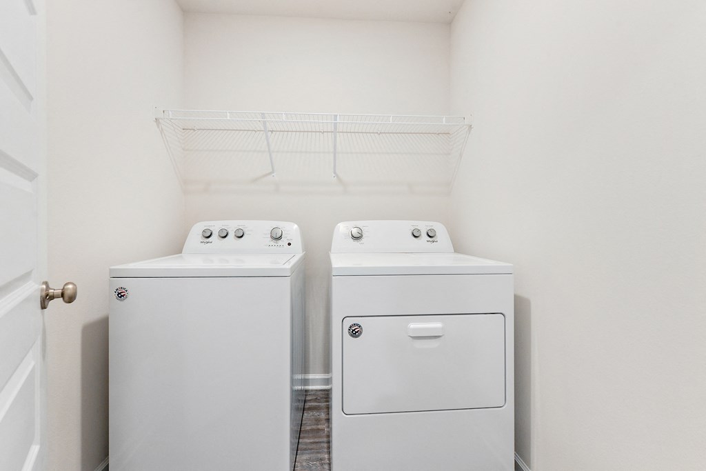 an empty laundry room with two washes and a dryer