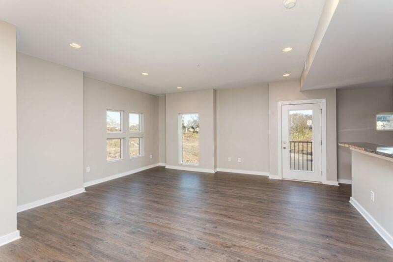 an empty living room with wood floors and a door