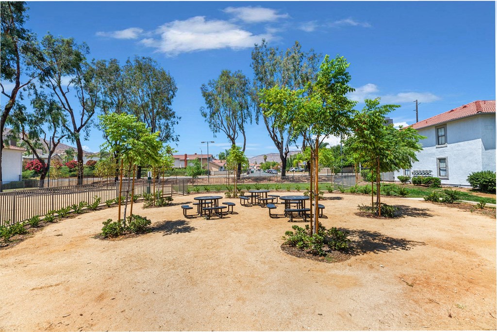 Apartments for Rent in Moreno Valley, CA - Sorelle Apartments - Picnic Area with Fence, Trees, Round Tables, and Benches