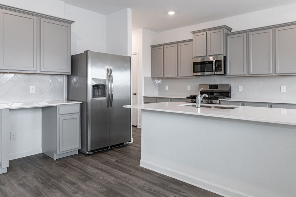a kitchen with gray cabinets and a white counter top