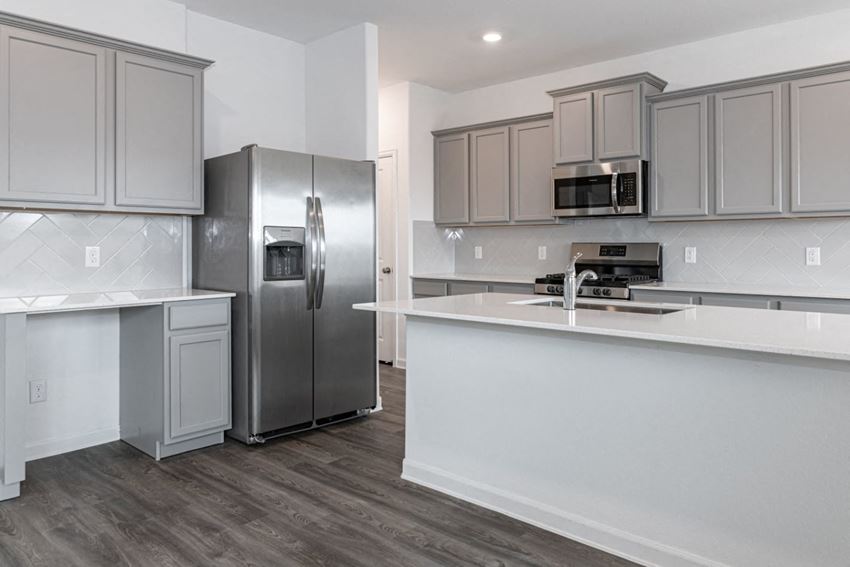 a kitchen with gray cabinets and a white counter top - Photo Gallery