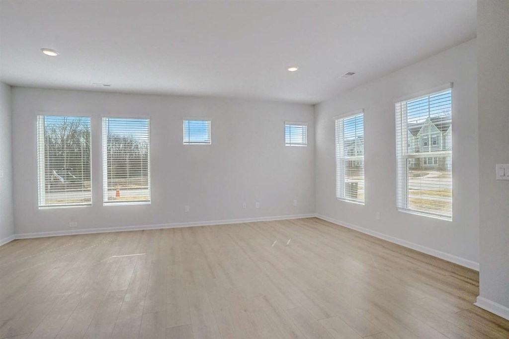 an empty living room with a hardwood floor