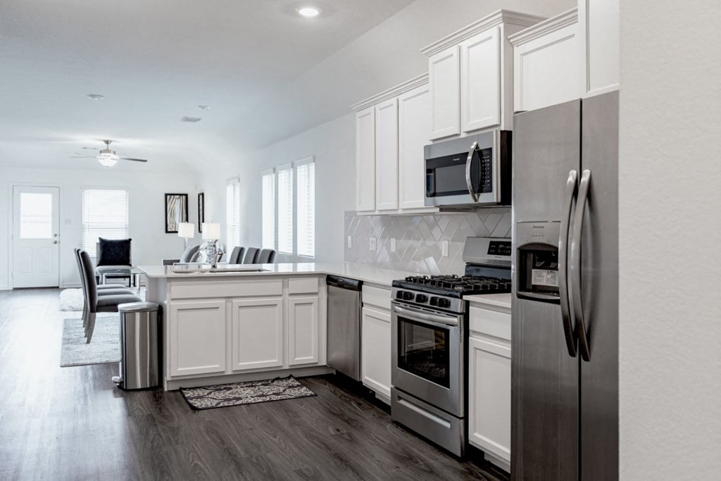 a kitchen with white cabinets and stainless steel appliances