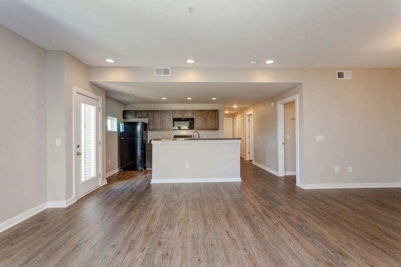 an empty living room with a kitchen and a