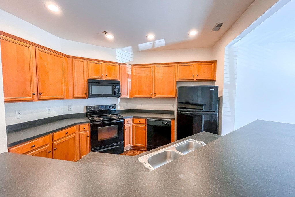 a kitchen with black appliances and wooden cabinets
