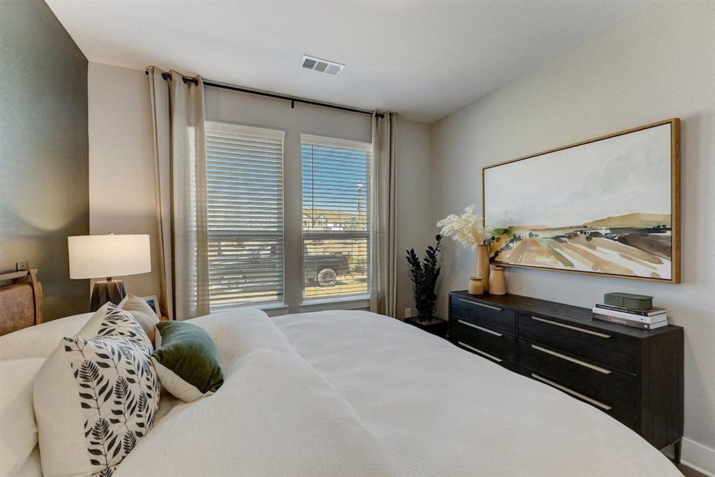 a bedroom with a large window and a large bed