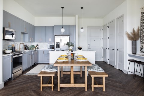 A modern kitchen with a dining table set for two.