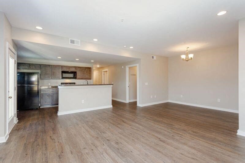 an empty living room with a kitchen and a
