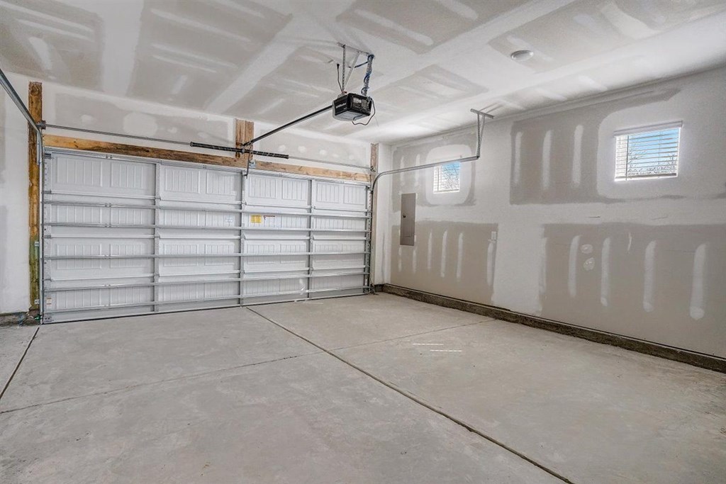 A spacious garage with a closed white door and a window.