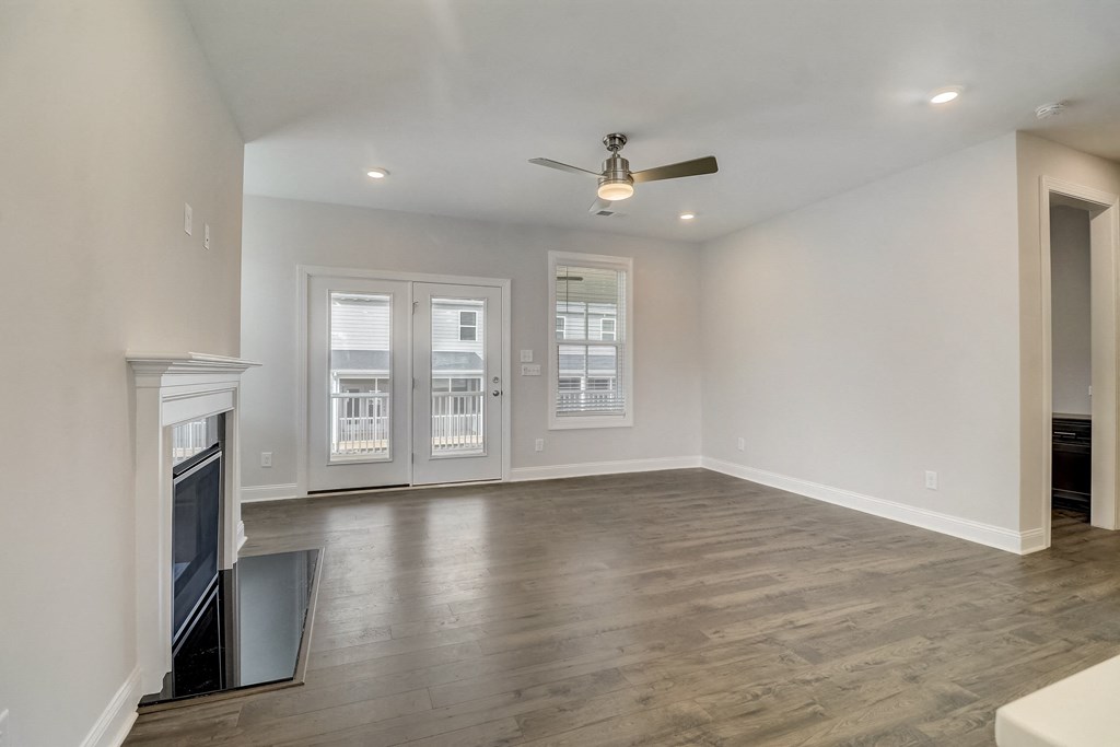 a living room with a fireplace and a ceiling fan