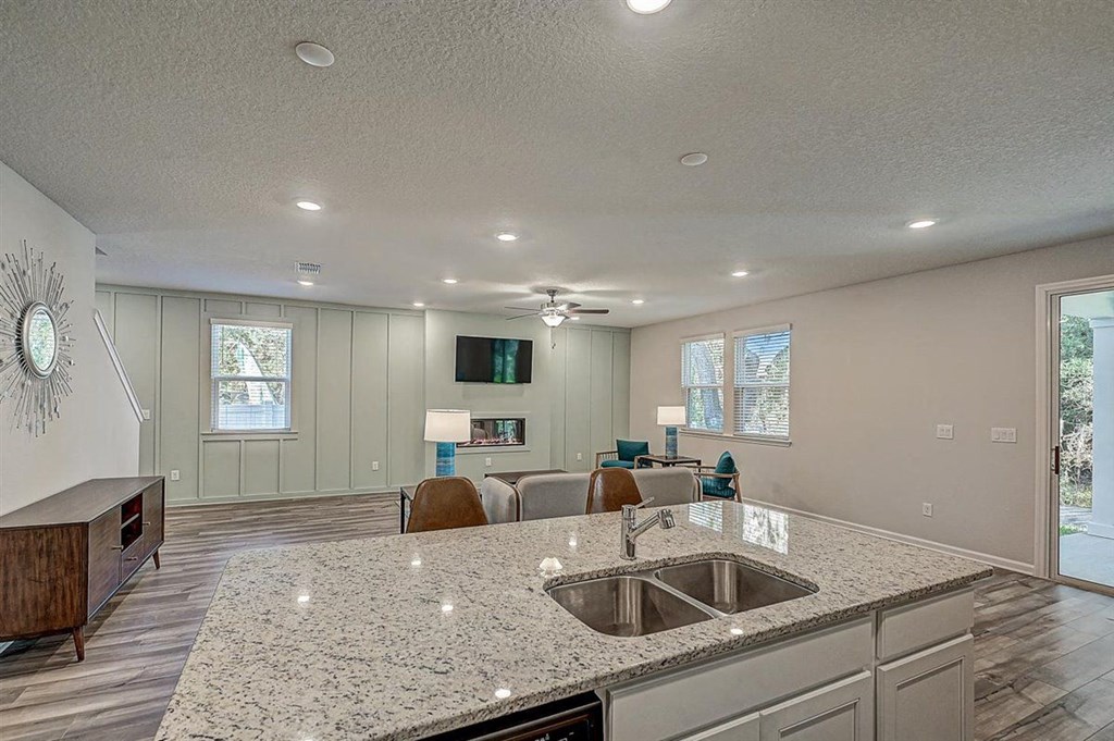 Open-concept living space with kitchen island, living room, and light green walls.