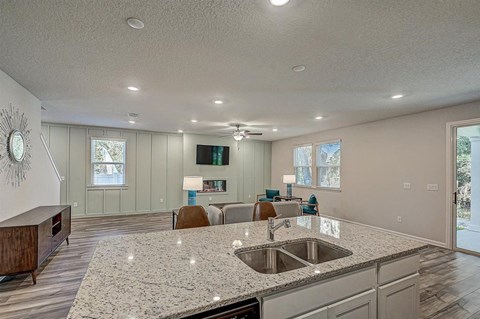 Open-concept living space with kitchen island, living room, and light green walls.