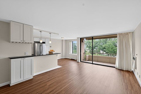 A kitchen with wooden floors and white cabinets.