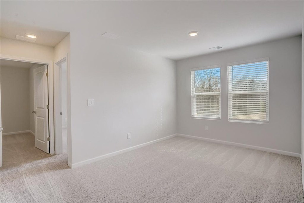 an empty room with two windows and a door