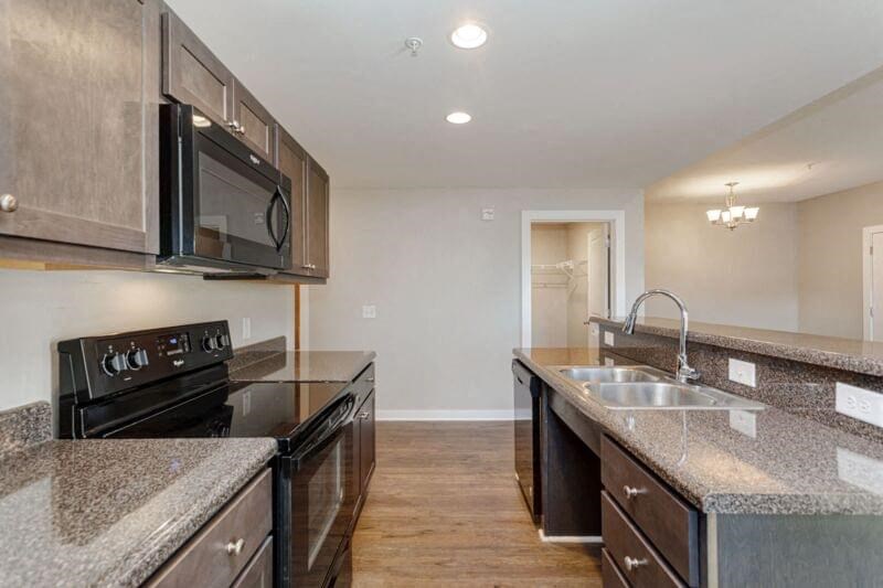 a kitchen with granite counter tops and black appliances