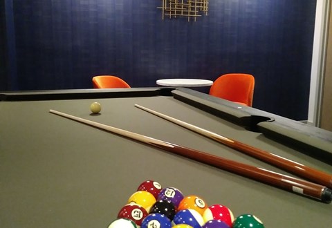 A pool table with a few balls and cues.