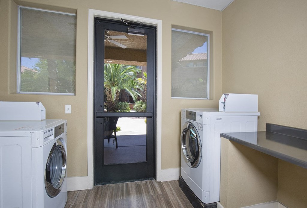 a laundry room with two washing machines and a door to a patio