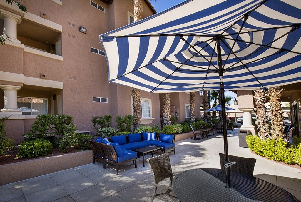a patio with an umbrella and a table with chairs