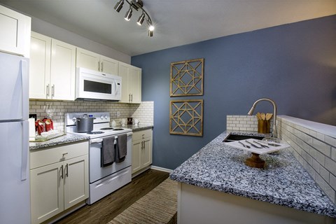 a kitchen with white appliances and a counter top