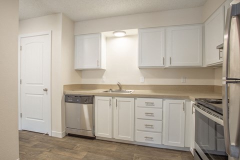 a kitchen with white cabinets and stainless steel appliances